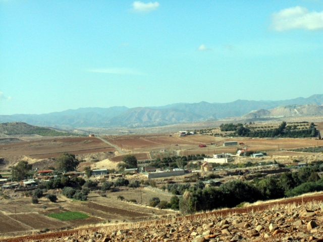 Figure 41: Kato Koutraphas village from the south-east, with the church of Panayia Chryseleousa (TP244) centre right (between the two concrete walls), and Skouriotissa mine in the background at the right. Photograph: Michael Given. 