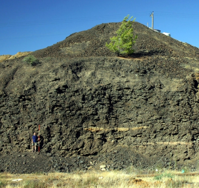 Figure 16: Section through Skouriotissa slag heap (TP007). Two layers of workshop floors can be seen, as well as the different fragmentation of the slag cakes. Photograph: Michael Given. 