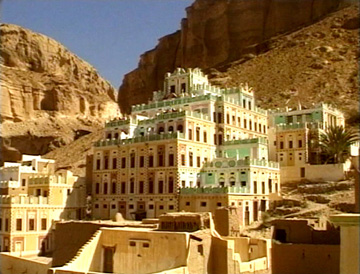 Image of a mud brick buildings several stories high.