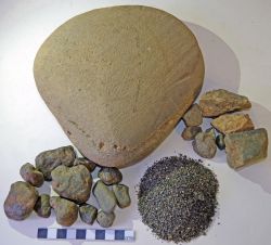 The contents of one of the Bronze Age cassiterite pits from Truro, showing muller, cassiterite pebbles and processed cassiterite ore (photograph Sean Taylor, Copyright Cornwall Archaeological Unit).