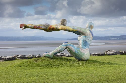 Sculpture of a female swinging a child around in the air