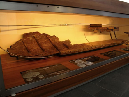 The remains of a small shipwrecked boat, on display in a museum