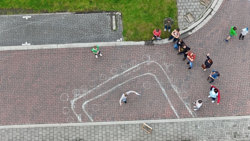 Aerial view of chalked outlines of archaeological features in the urban landscape.