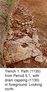 Trench 1: Path (1135) from Period 5.1, with drain capping (1130) in foreground. Looking north.